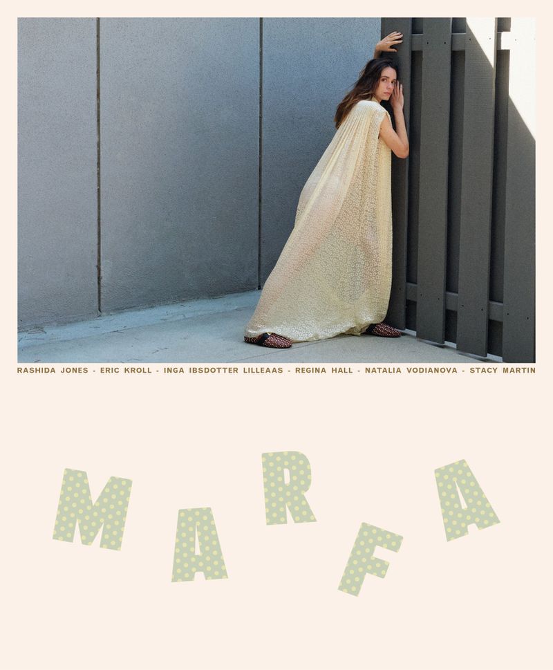 Stacy Martin in a textured cream floor-length gown leaning against a dark slatted fence for MARFA magazine cover.