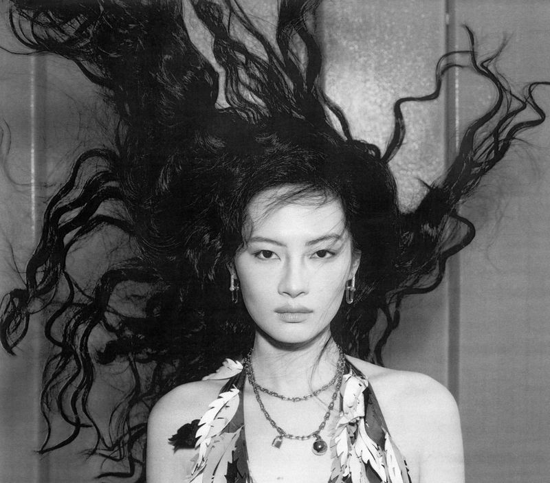 Model Wenyu Zhao with flowing dark hair and layered necklaces in a black and white editorial photograph for Harper's Bazaar China.