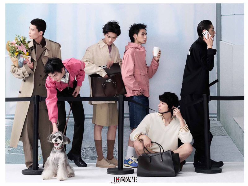 Group of styled male models waiting behind stanchions with a small dog for an Esquire China menswear editorial.