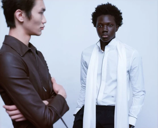 Two male models posing in contemporary menswear against a clean white seamless studio background.