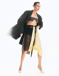 Model Nieves Alvarez wearing a dark coat and asymmetric skirt for Mujer Hoy photographed by Charly Calderon.