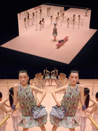 Two women with bags stand near ballet barres with ballerinas in the background, all on a pink stage with a dark backdrop.