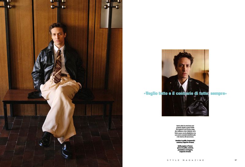 Dario Aita seated on a wooden bench wearing a black leather jacket, tie, and pleated beige trousers for Style Magazine Italy.