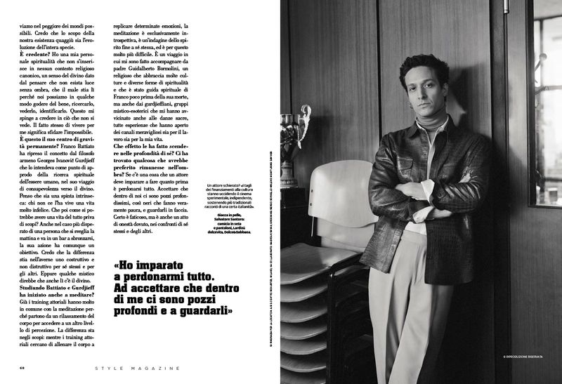 Black and white editorial magazine spread featuring a man in a textured jacket and wide trousers leaning against a wood panel wall.