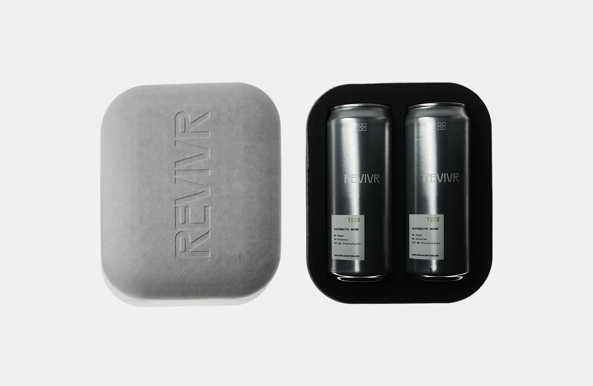 REVIVR electrolyte drink packaging with two silver cans in a black tray beside an embossed grey molded case against a white background.