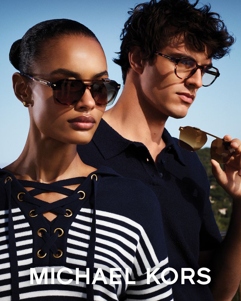 Ana Beatriz Cortes and Francesco Ruggiero wearing Michael Kors eyewear under bright blue sky.