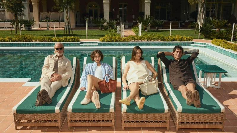 Four models lounging on green-cushioned sunbeds by a tiled swimming pool for Tod's Vacanze Italiane campaign