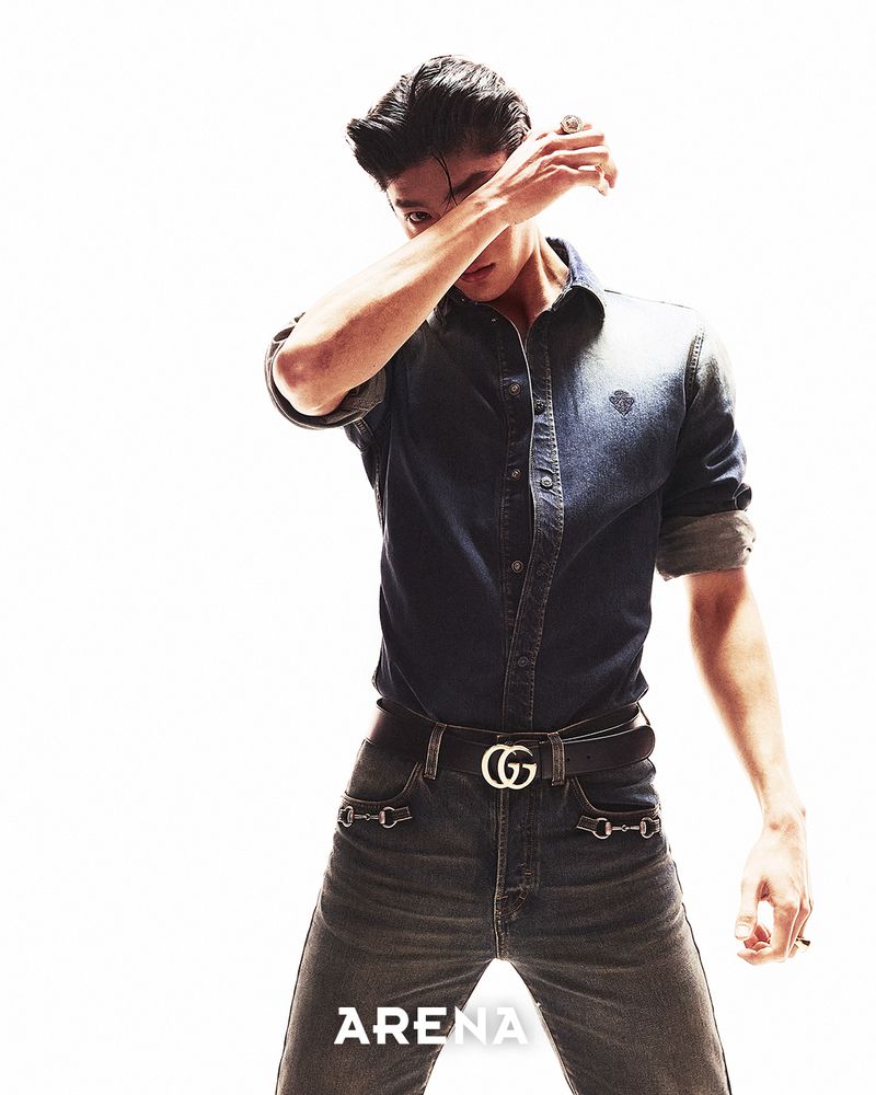 Model Woohyeong Jang wearing a denim shirt and belted jeans against a white seamless background.