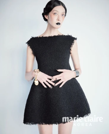 Model So Young Kang wearing a black mini dress with dark lipstick and metallic accessories against a white background for Marie Claire Korea.
