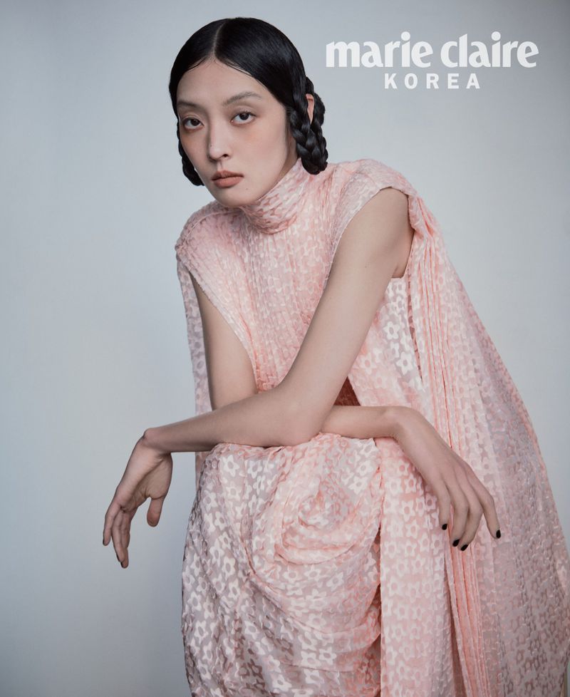 Model So Young Kang posing in a textured pastel pink high-neck sleeveless dress against a neutral studio backdrop for Marie Claire Korea.