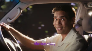 Man driving a car smiling at the camera with text overlay for Queensland Government Coercive Control TVC campaign