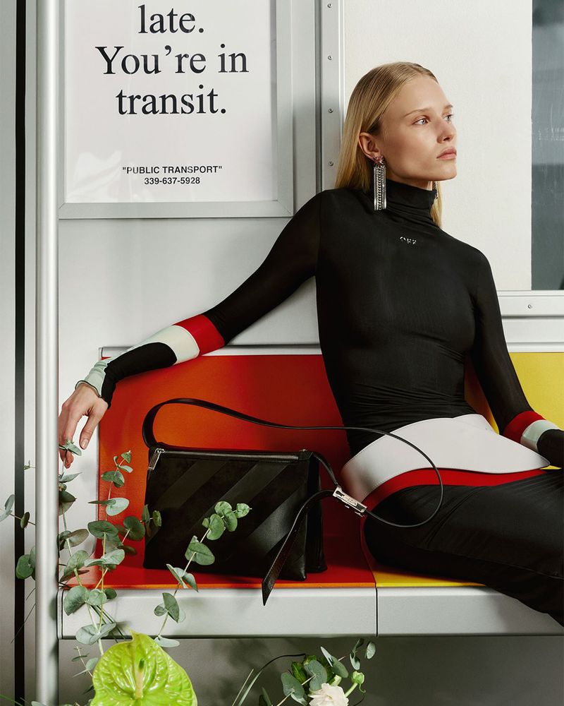 Katrine Steiness seated on a subway-style bench in a black turtleneck top next to a black leather handbag for Off-White.