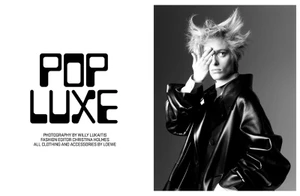 Black and white editorial portrait of a model with spiky hair covering one eye wearing a dark leather coat against a gradient background.