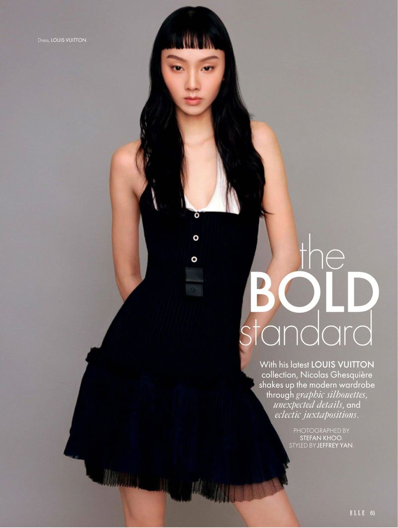 Fashion editorial shot of an Asian woman in a black dress with a white top, photographed in a photo studio with soft lighting.
