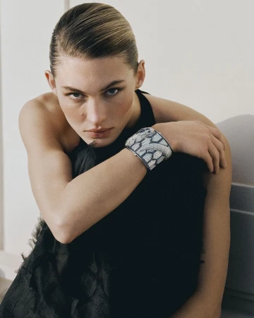 Model Grace Elizabeth wearing a black top and an ornate silver cuff bracelet against a neutral backdrop.