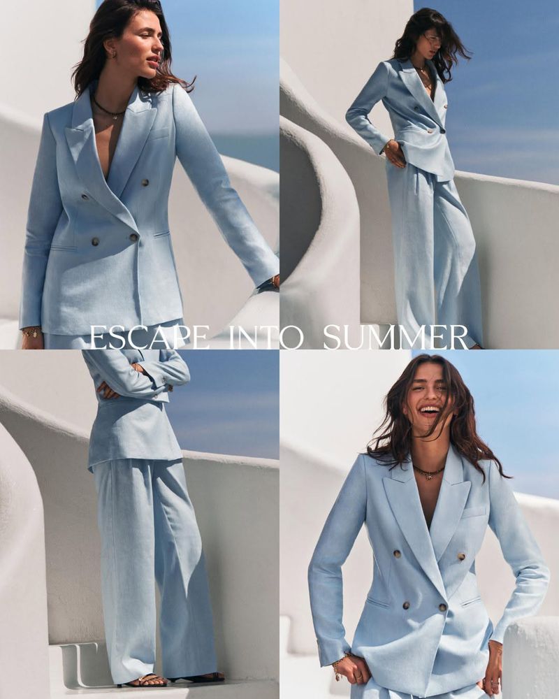 Four-panel photo of a woman wearing a light blue double-breasted pantsuit on sunlit white architectural stairs overlooking the sea.