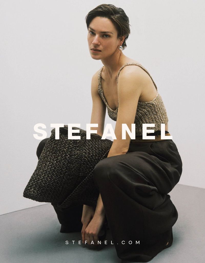 Model Lisa Louis Fratani crouching in a knit tank top and dark wide-leg trousers for the Stefanel campaign.