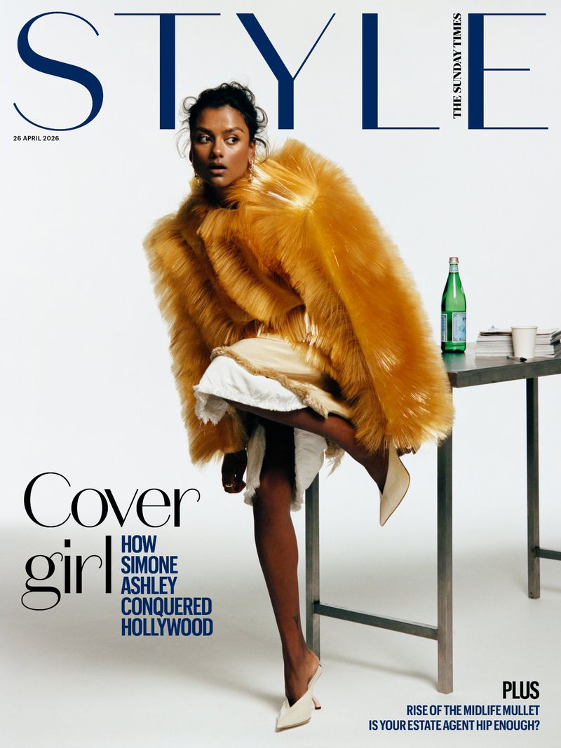 Simone Ashley posing on a studio table in an oversized textured ochre jacket and pointed mules for The Sunday Times Style cover.