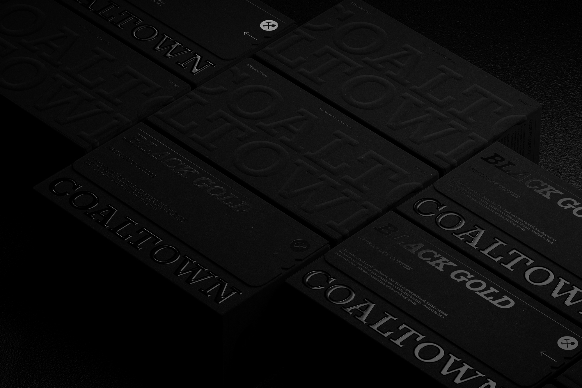 Monochromatic black packaging boxes and cards for Coaltown Coffee featuring embossed and debossed typography.