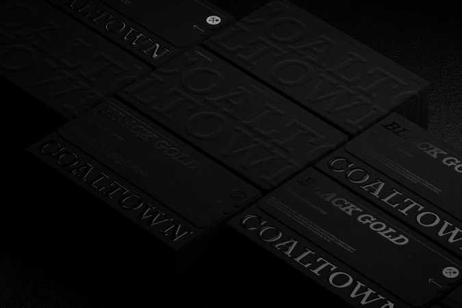 Monochromatic black packaging boxes and cards for Coaltown Coffee featuring embossed and debossed typography.
