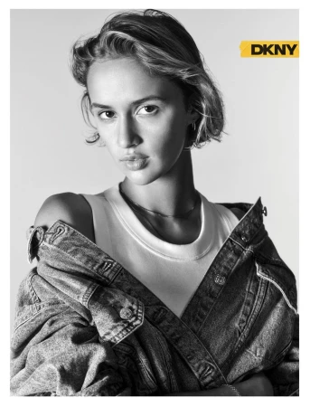 Model Quinn Mora wearing an off-the-shoulder denim jacket and white tank top in a black and white portrait for DKNY.
