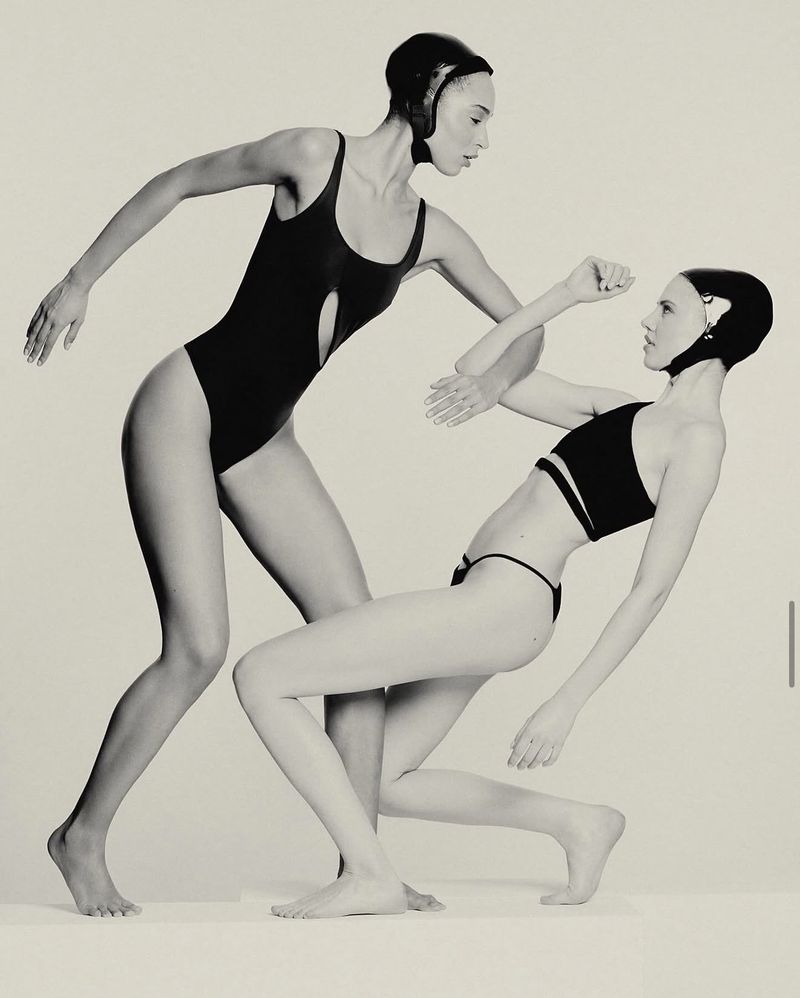 Two female models in black swimwear and swim caps posing against a light background for Max Zara Sterck.