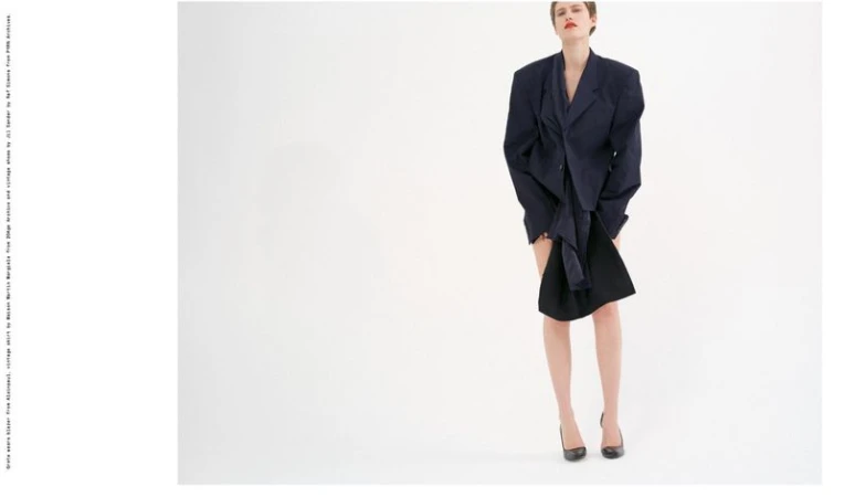 Model Greta Hofer poses in an oversized dark tailored blazer and heels against a white seamless background for Endless Magazine.