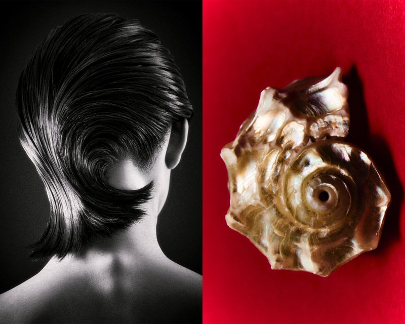 Monochrome studio shot of a woman’s stylized short hair next to a spiral seashell against a red background.