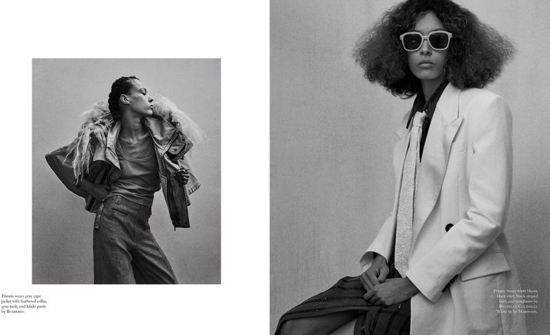 Black and white fashion shot of two women wearing tailored clothing and sunglasses in an indoor studio setting with soft lighting.