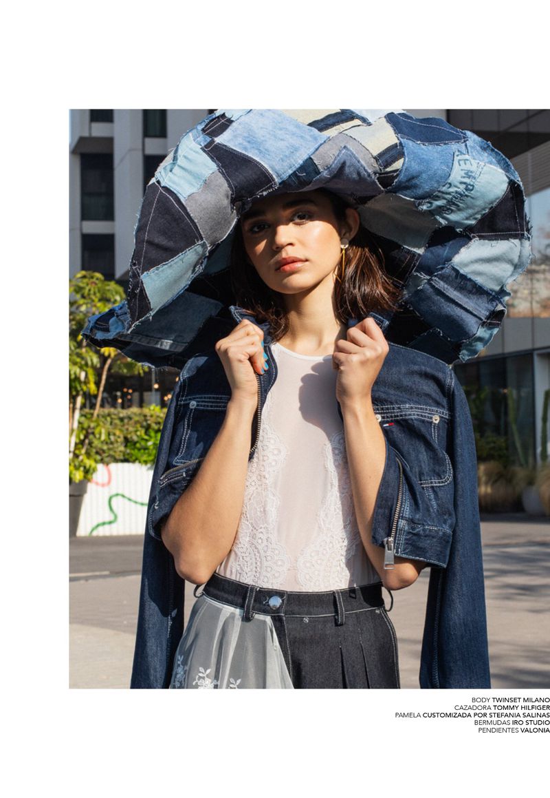 Model wearing an oversized patchwork denim headpiece and dark denim jacket outdoors for Avenue Illustrated.
