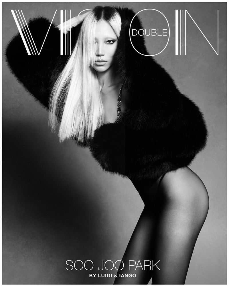 Model Soo Joo Park posing in a voluminous black fur jacket and sheer tights against a grey studio backdrop for Double Vision.