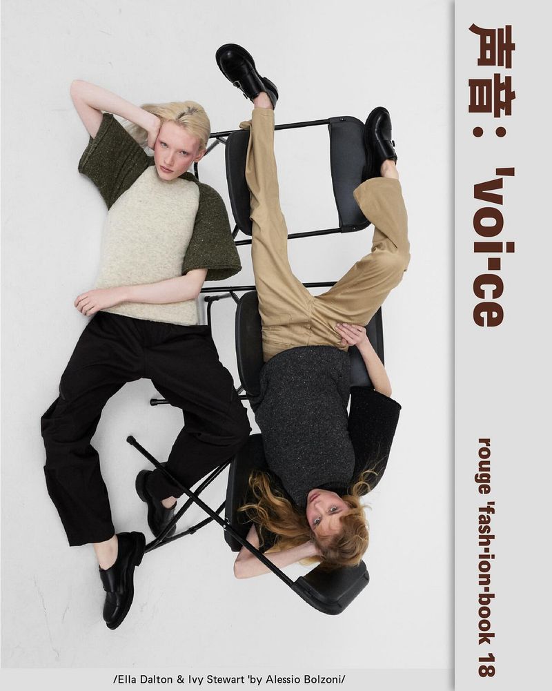 Two models posing with black folding chairs against a white studio background for Rouge Fashionbook issue 18.