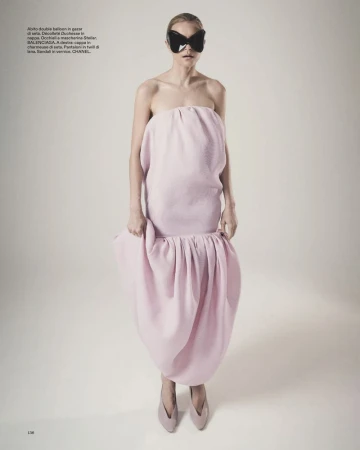 Jessica Stam in a strapless pink balloon dress and black butterfly sunglasses against a pale studio backdrop.