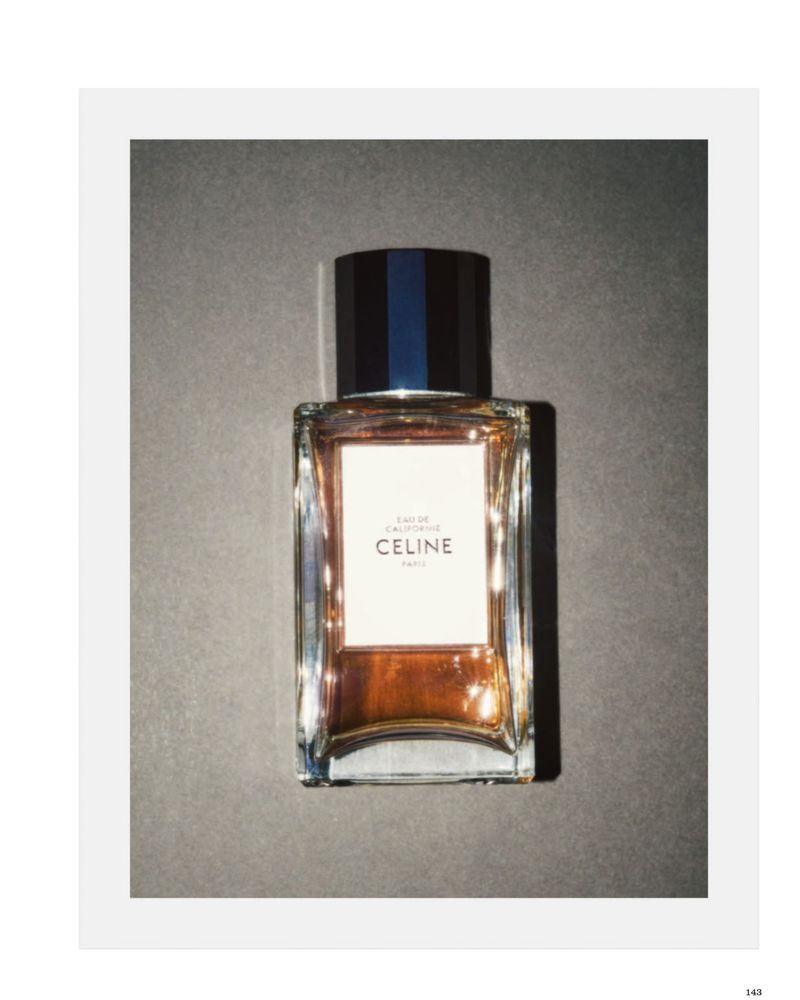 A rectangular glass bottle of Celine perfume with an amber liquid and black cap against a grey background.