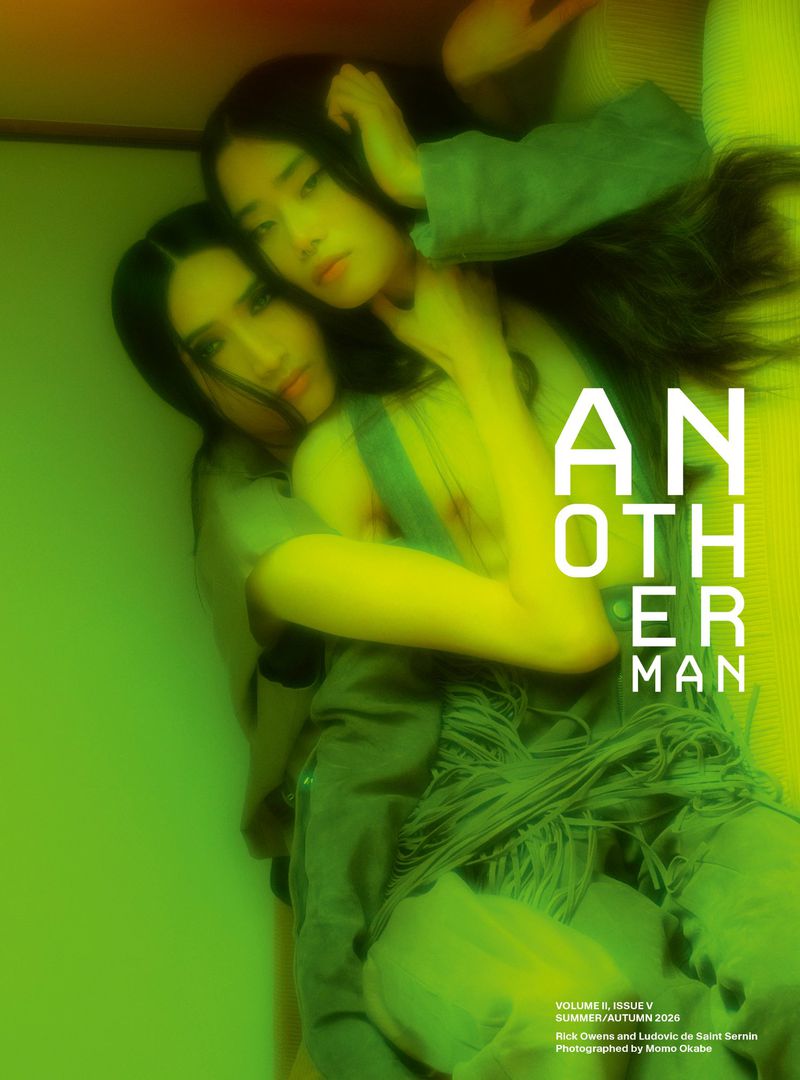Two models embracing under ambient green light on the cover of AnOther Man Magazine Volume II Issue V.