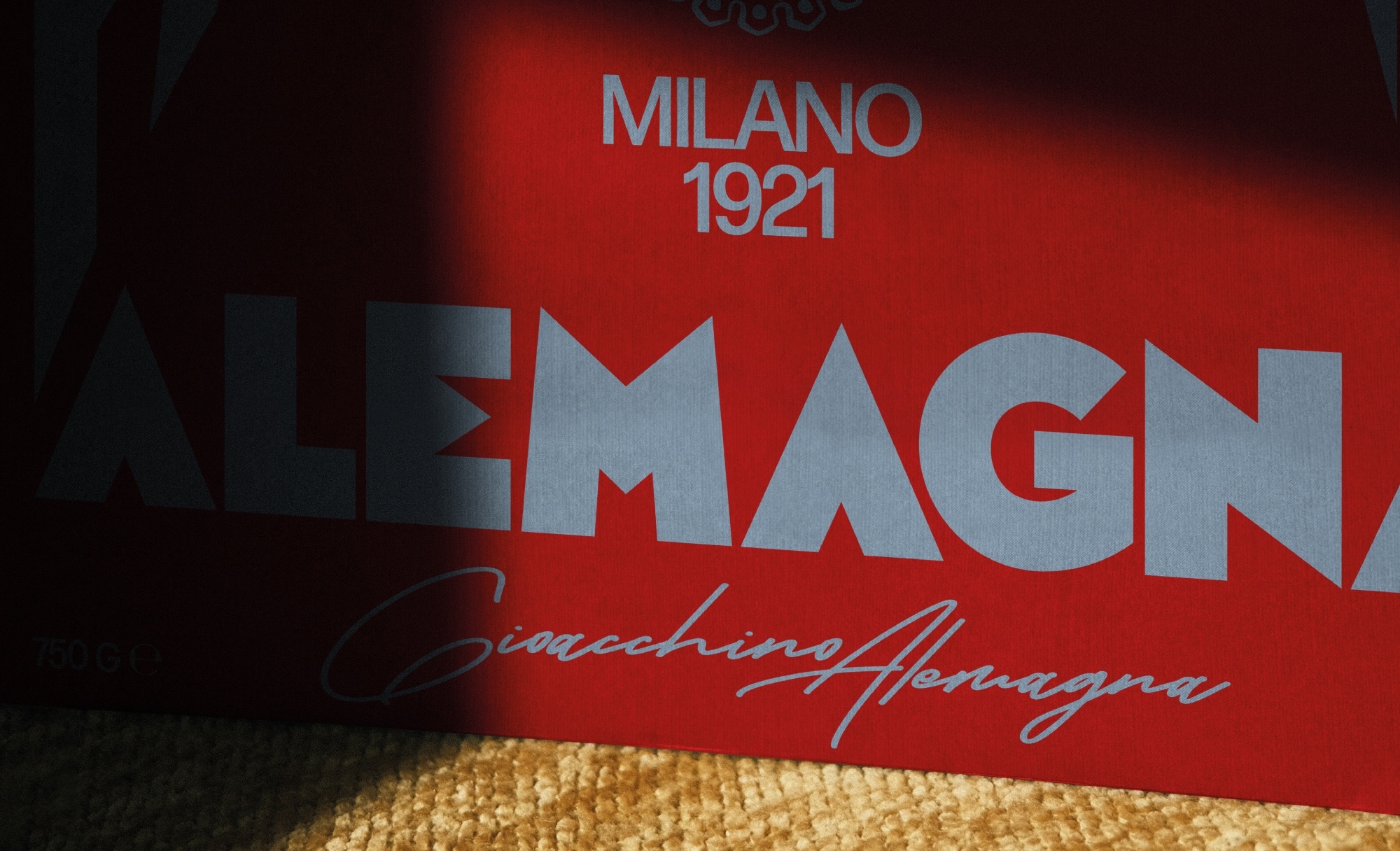 Close-up of a red Alemagna box with white typography under directional lighting.