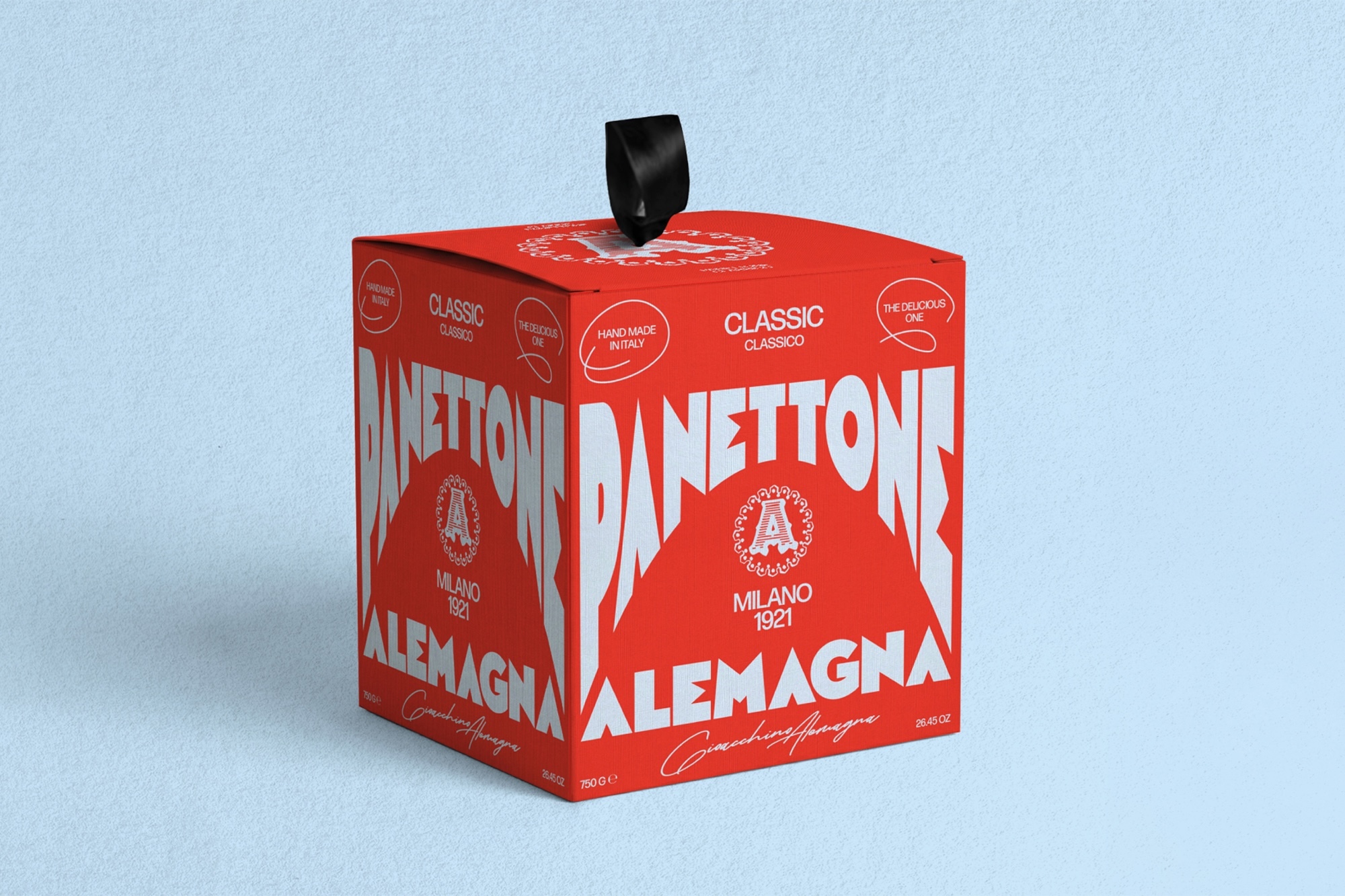 Red panettone packaging box with white typography and a black ribbon handle against a pale blue textured background