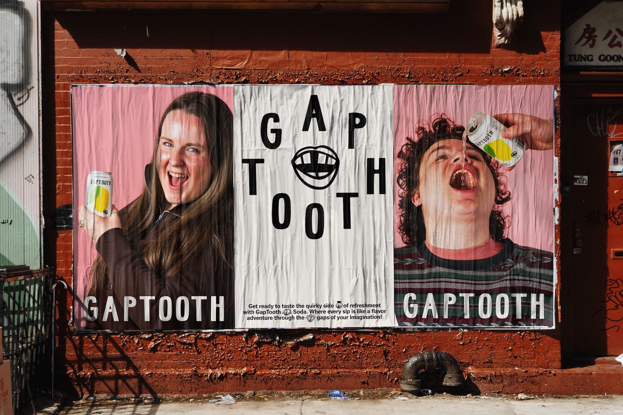 Wheatpaste poster advertisement for Gaptooth brand on a weathered red brick wall showing typography and two panels with people drinking soda.