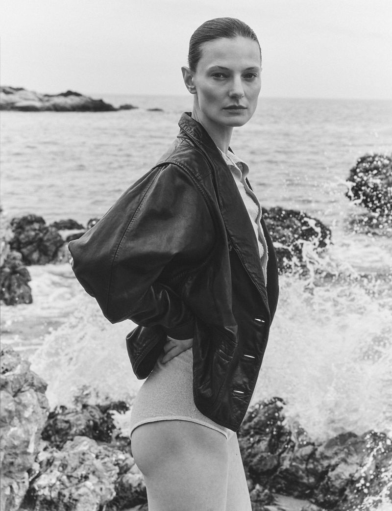 Monochrome portrait of model Tanya Ruban wearing a dark leather jacket by the rocky coast for Flair Germany