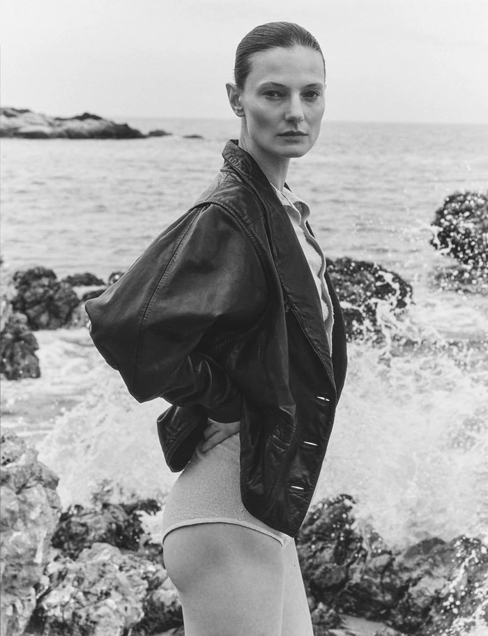 Monochrome portrait of model Tanya Ruban wearing a dark leather jacket by the rocky coast for Flair Germany