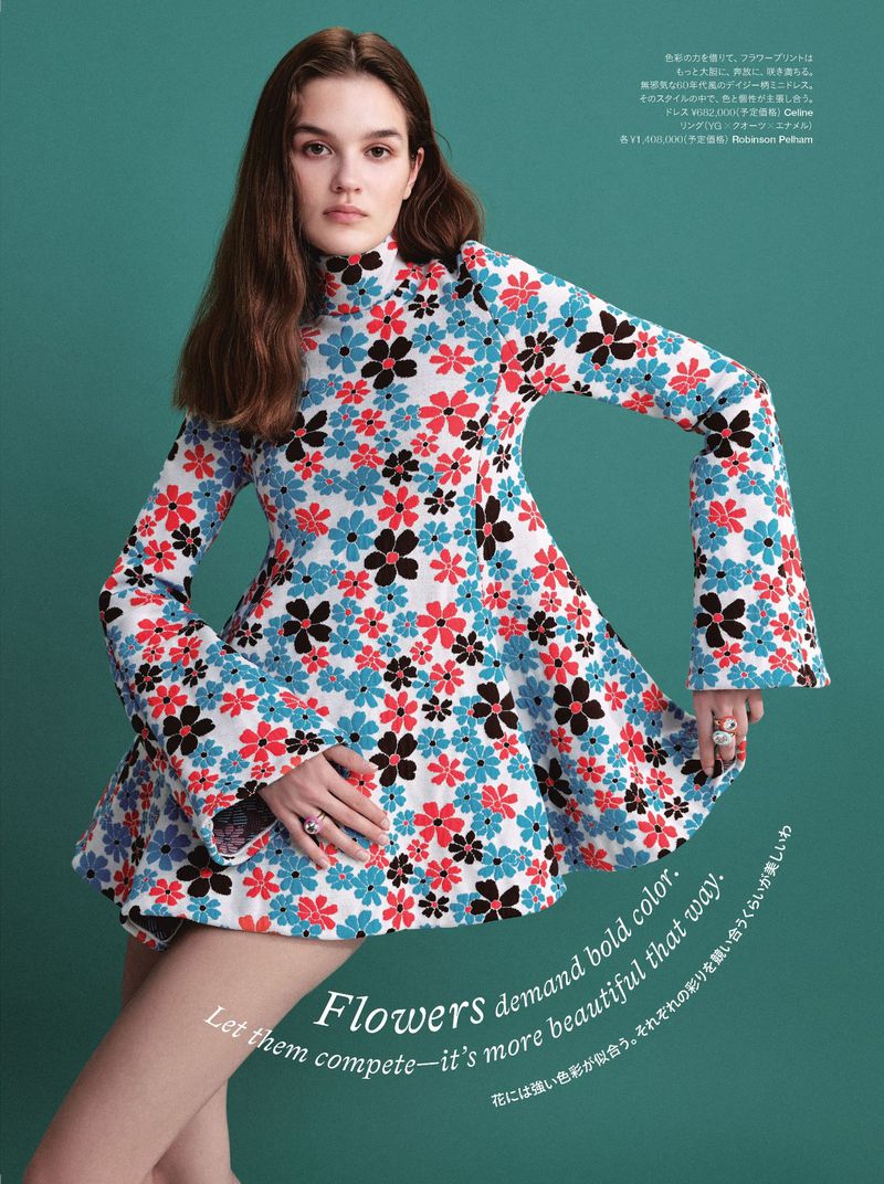 Model wearing a retro floral print mini dress with flared sleeves against a solid teal background for Harper's Bazaar Japan