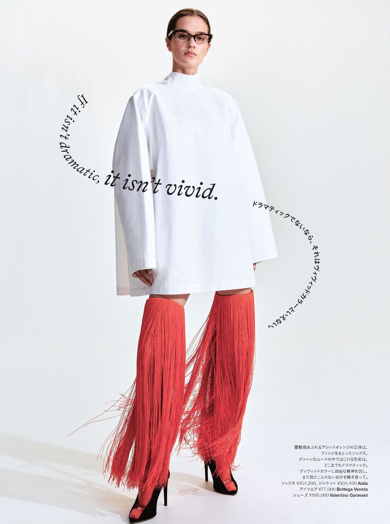 Model wearing a white tunic and red fringe boots against a seamless white studio background for Harper's Bazaar Japan