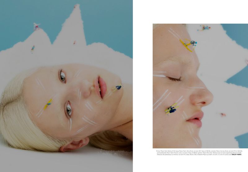 Close-up split image of a model with miniature skiers on her face and white set pieces resembling snowy mountains against a blue background.