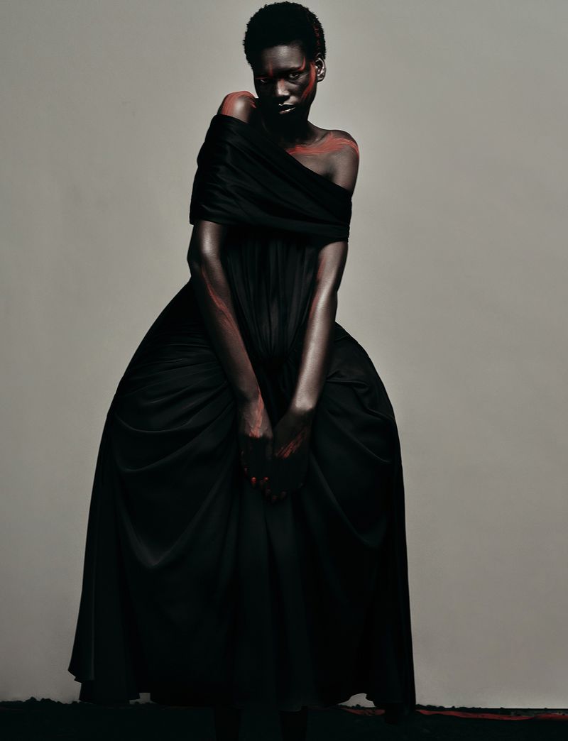 Model Nyagoa Diu wearing a black off-the-shoulder gown against a neutral studio background for Numero Netherlands.