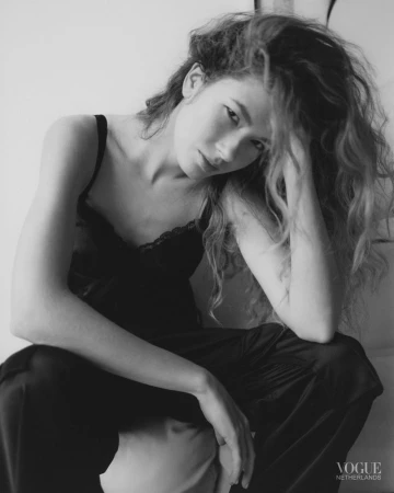 Model Meg Dmitruk wearing a black lace-trimmed camisole in a black and white fashion editorial portrait for Vogue Netherlands.