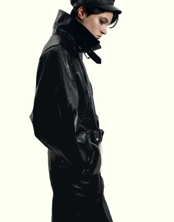 Model wearing a black leather coat and cap against a solid white background for HERO Magazine