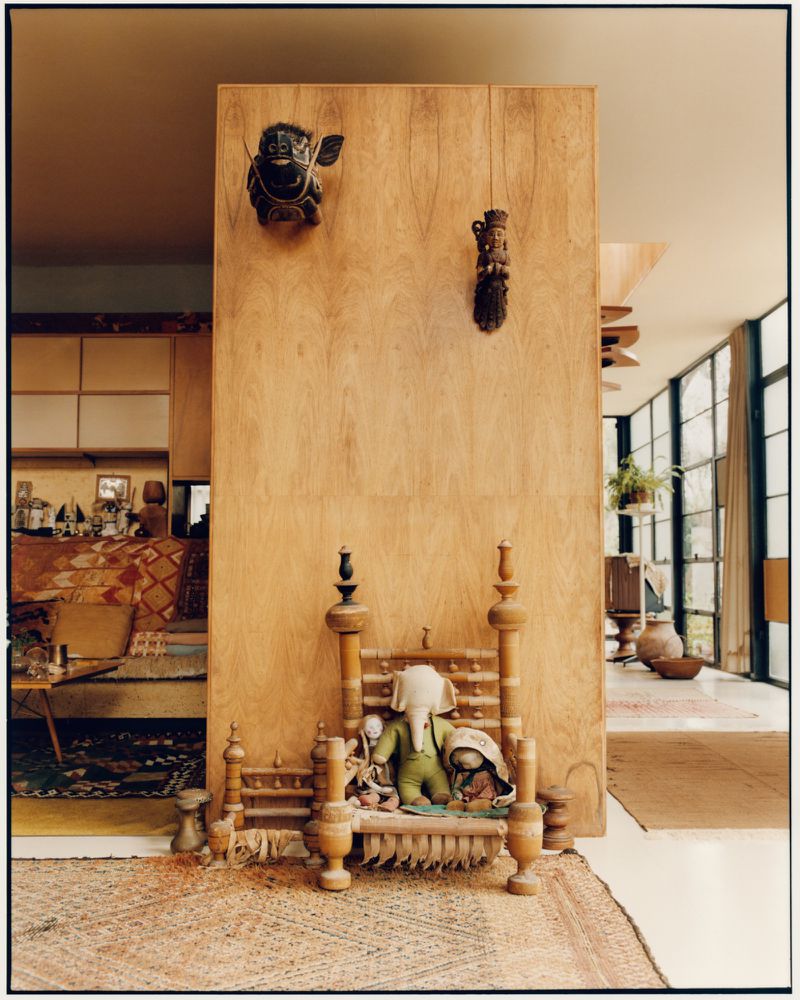 Interior view of wooden paneling and decorative objects displayed inside the Eames House with natural light.
