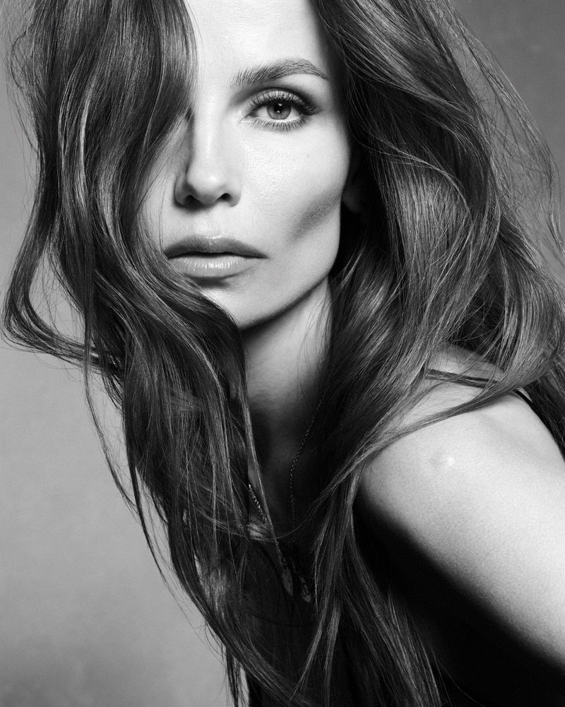 Close-up portrait of model Natasha Poly in monochrome with long tousled hair falling across her face.