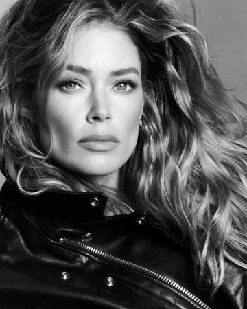 Close-up black and white portrait of model Doutzen Kroes wearing a dark leather jacket with metal snaps.