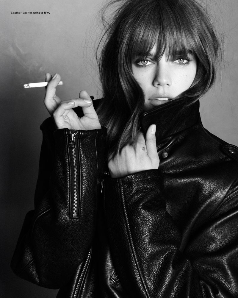 Model Betsy Gaghan wearing a black leather jacket and holding a cigarette in a monochrome portrait for Double Vision Betsy.